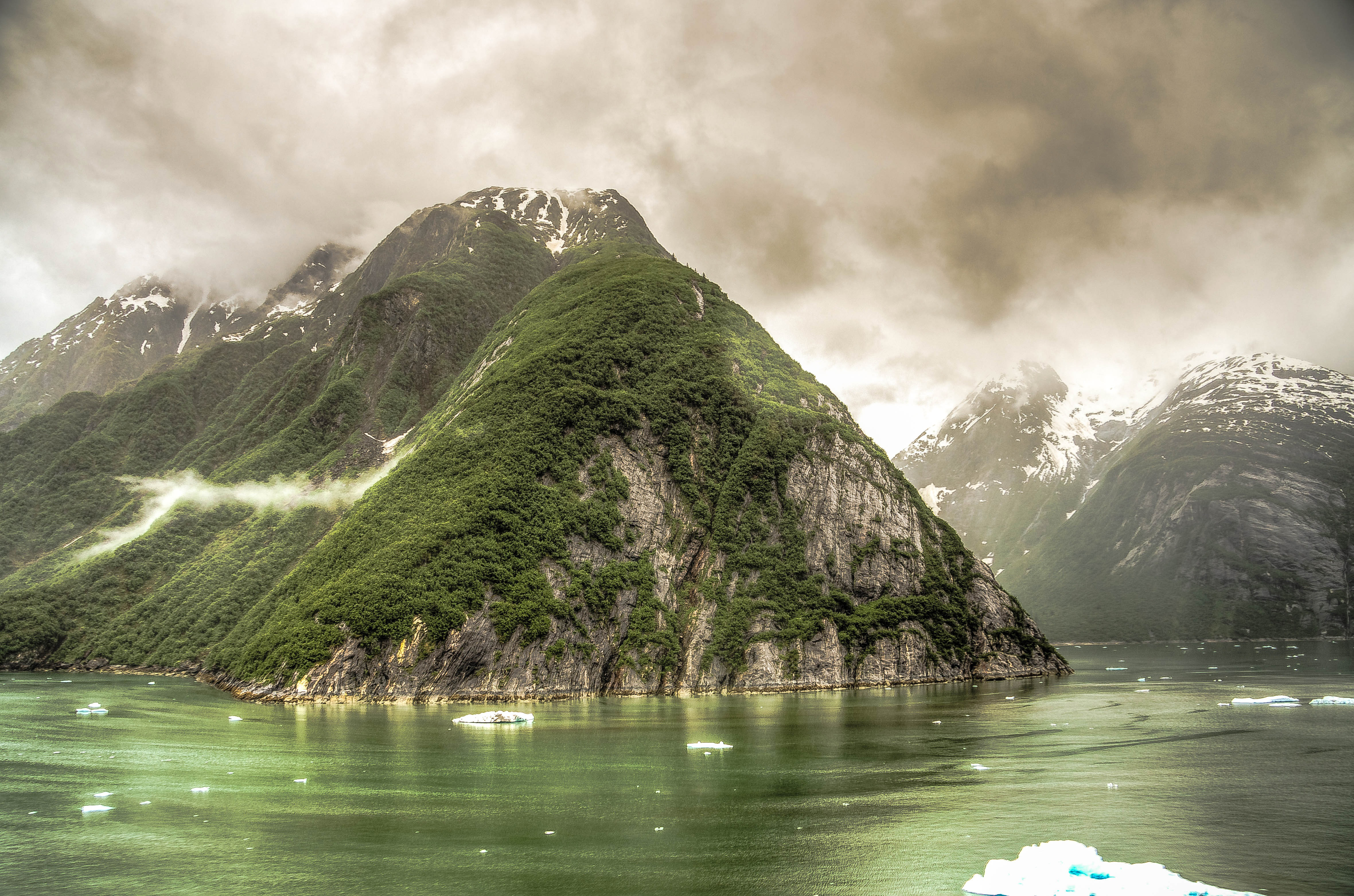 Photo of black clouds over rising hills in the fjord around juneau alaska