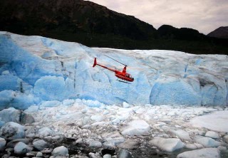 Photo of Helicopter flying past blue glacier wall