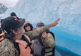 Photo of guest touching iceberg on tour