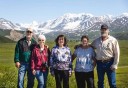 Photo of tour group in front of beautiful mountain peaks