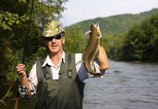 Photo of man holding caught salmon